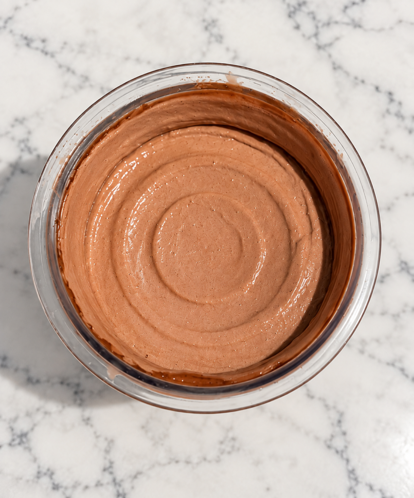 Overhead view of creamy chocolate Ninja Creami ice cream without protein powder in a pint container.