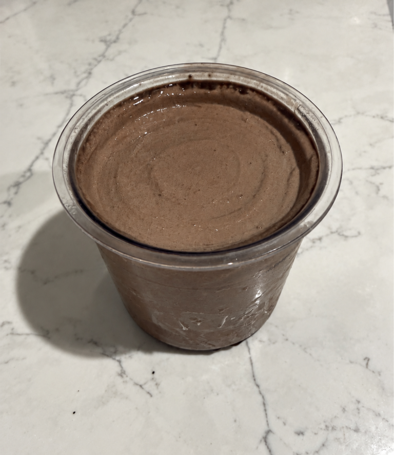 High-Protein Chocolate Cookie Blast Ninja Creami in a pint container with a smooth, creamy chocolate-cookie surface.