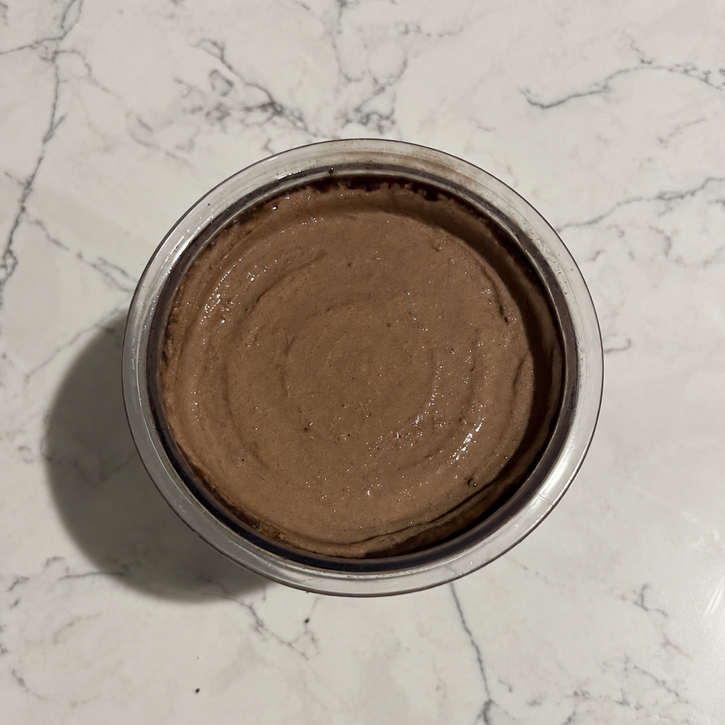 Overhead view of High-Protein Chocolate Cookie Blast Ninja Creami showing the smooth chocolate-cookie ice cream surface.