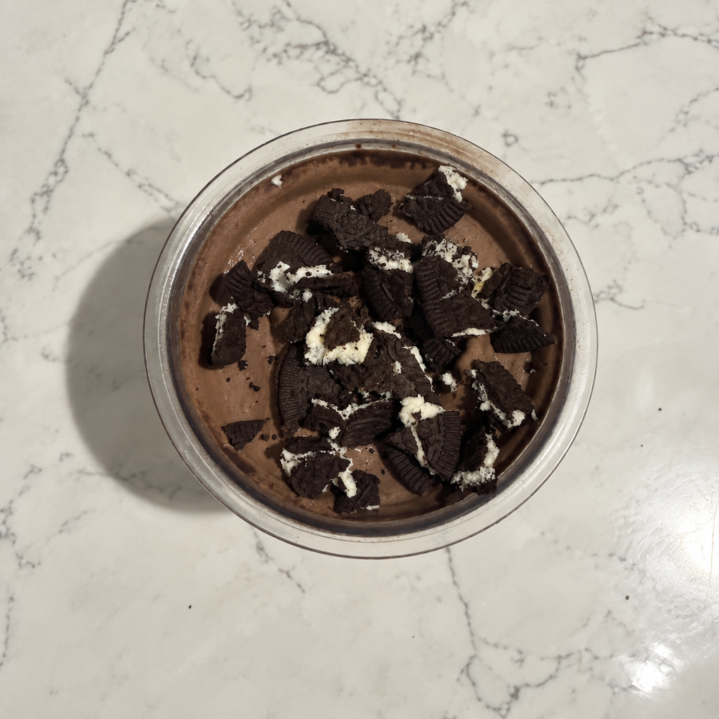 Overhead view of chocolate-cookie Ninja Creami ice cream topped with crushed Oreo Thins