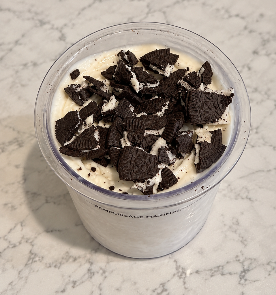 Caramel Macchiato Ninja Creami topped with three crushed Oreo Thins in a Ninja Creami pint