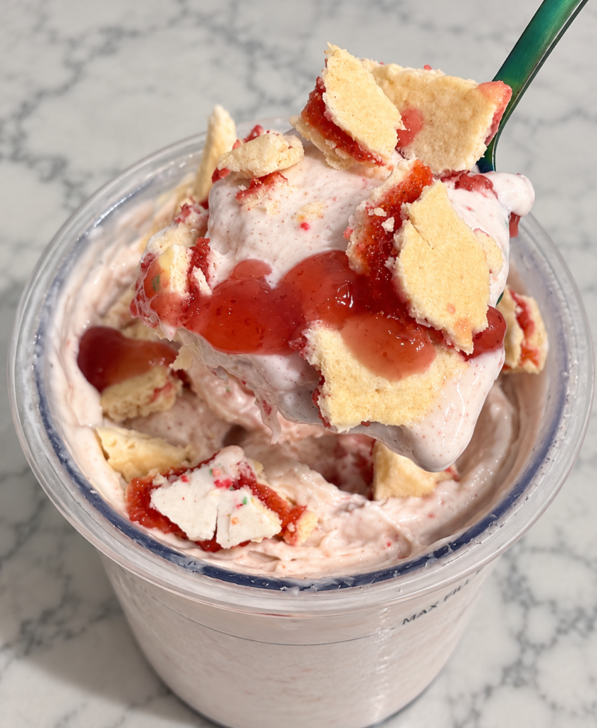 Green spoon lifting creamy Strawberry Pop-Tart Ninja Creami with strawberry spread and pastry pieces